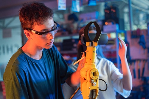 молодые специалисты в очках виртуальной реальности изучают роботизированную руку